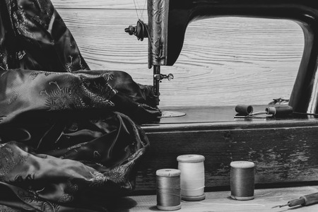 monochrome still life with antique sewing machine and a variety of sewing accessoriesの写真素材