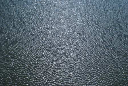 background - shiny glossy water surface with ripples and sky reflection