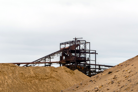 desert industrial landscape with stationary rusty gravitational separator of sand and gravel on the horizonの写真素材