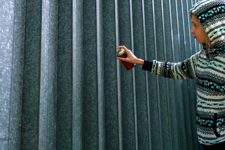 teen girl with spray paint is going to write graffiti on the wallの写真素材