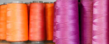background - bobbins of red and purple threads closeup