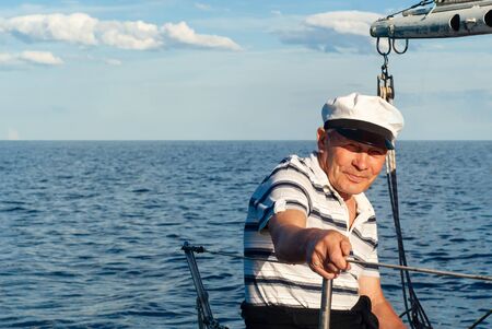 old sailor on his sailboat against a seascape
