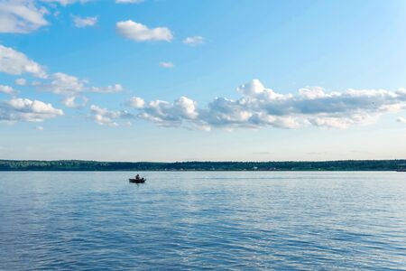 wide summer river with a fishermanâs boatの写真素材