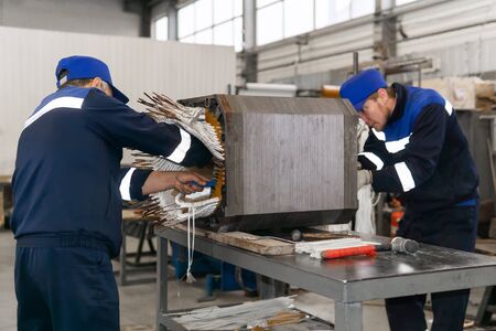 Perm, Russia - October 11, 2019: workers repairing a stator winding of an electric motor in a workshopのeditorial素材