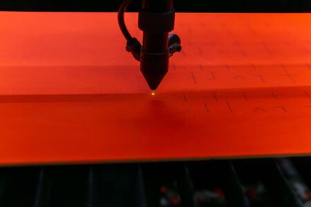 Laser cutting of grooves in an orange plywood blank, close-upの写真素材