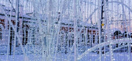 background - decoration of electric Christmas lights on a winter street in the evening close-upの写真素材