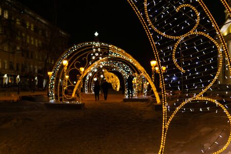 Perm, Russia - December 24, 2019: Christmas decorations from luminous electric garlands on a city street at night, blurred background,のeditorial素材