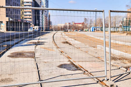 Perm, Russia - April 15, 2020: construction of the tram network was suspended due to quarantine during the COVID-19 pandemic; unfinished railways on a background of a deserted city streetのeditorial素材