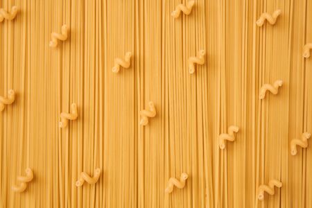 background of long and short-cut dry pasta, spaghetti and corkscrews