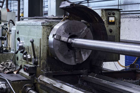 oiled lathe with a workpiece fixed in the spindle faceplate in the workshopの写真素材