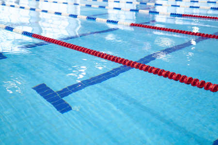 background - fragment of the competition pool with blue water and marked swimming lanesの写真素材