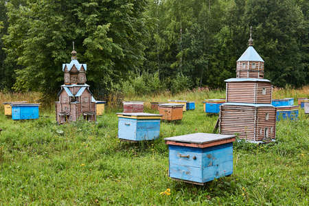 Perm, Russia - August 13, 2020: vintage hives in the form of temples among ordinary hives in a forest apiaryのeditorial素材