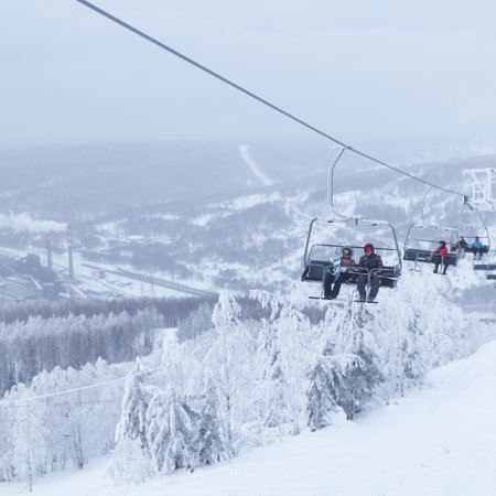 Perm Krai, Russia - January 02, 2021: skiers uses the chairlift against a foggy winter landscape in the valleyのeditorial素材