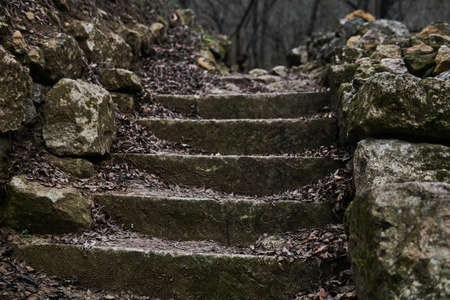 antique staircase made of natural stone in a gloomy autumn landscape outdoors close up