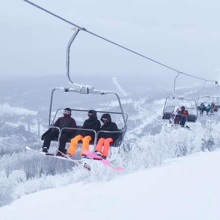 Perm Krai, Russia - January 02, 2021: skiers taking a chair lift in a hilly winter landscape