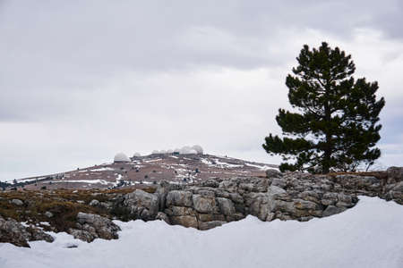 white domes of the radar complex on a hilltop on a cold plateau