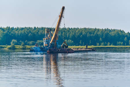 dredging boat is working to deepen the fairway on the riverの写真素材