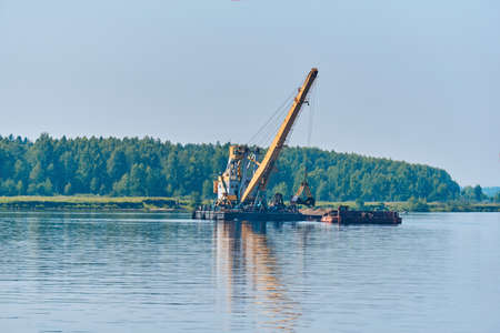 dredging boat is working to deepen the fairway on the riverの写真素材