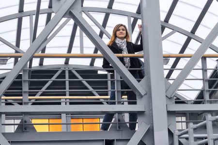young woman among the metal structures of the covered overpass