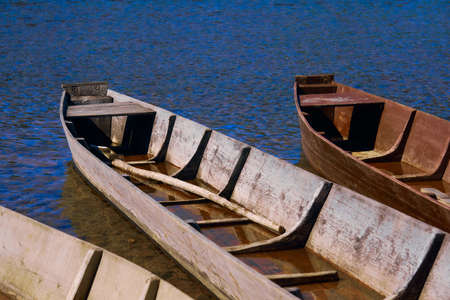 traditional fishing wooden flat-bottomed boats on the river bank, rural landscape