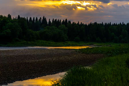 summer sunset over the northern river with wild wooded banks