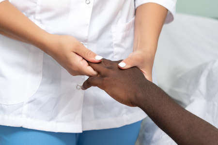 woman masseuse doing hand and palm massage to black man