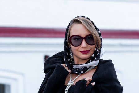 portrait of young woman in headscarf in retro style outdoorの写真素材