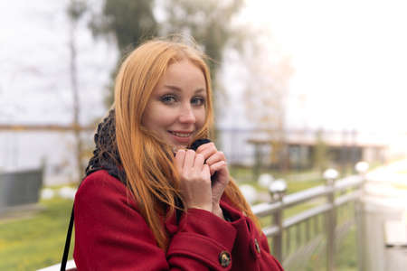 portrait of a red-haired girl slightly chilled in the autumn windの写真素材