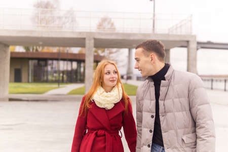 young couple walks along the autumn city embankmentの写真素材