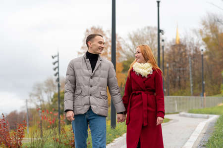 young couple walking and talking in autumn parkの写真素材