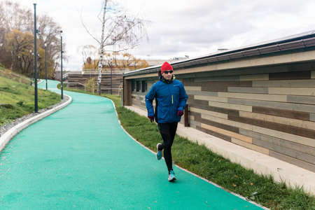 Perm, Russia - October 19, 2021: man jogging on all-weather running track in an urban environmentのeditorial素材