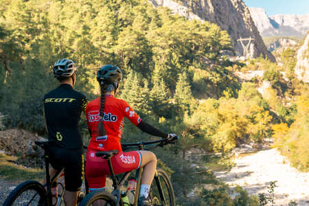 Kemer, Turkey - November 11, 2021: couple of cyclists look at a beautiful mountain valleyのeditorial素材