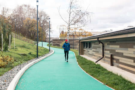 Perm, Russia - October 19, 2021: man jogging on all-weather running track in an urban environmentのeditorial素材