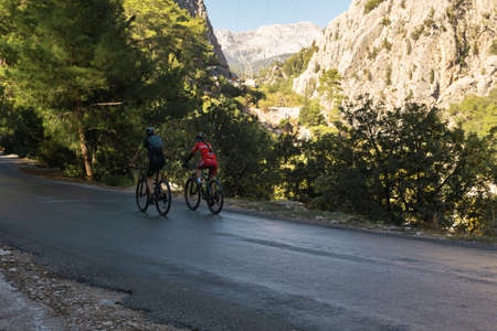 Kemer, Turkey - November 11, 2021: two cyclists riding a mountain roadのeditorial素材