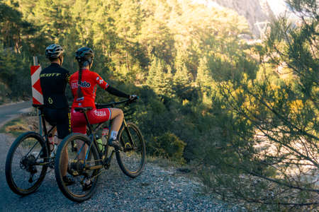 Kemer, Turkey - November 11, 2021: couple of cyclists look at a beautiful mountain valleyのeditorial素材