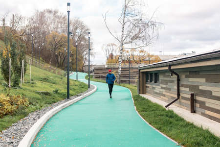 Perm, Russia - October 19, 2021: man jogging on all-weather running track in an urban environmentのeditorial素材