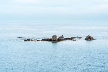 seascape with islets, rocks sticking out of the water on a reef bankの写真素材