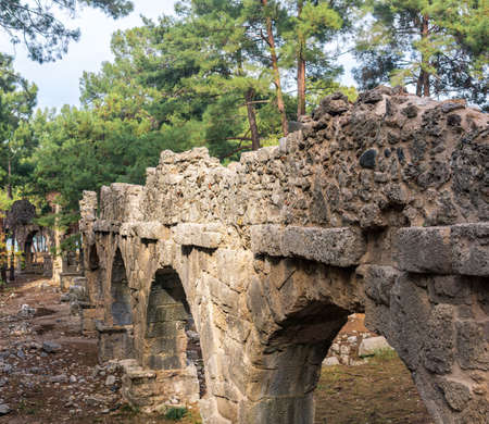 ruins of ancient Roman aqueduct among the forest in the antique city of Phaselisの写真素材