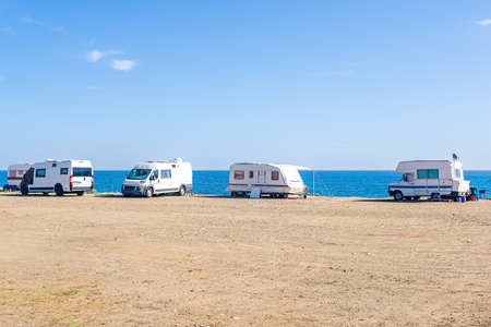 campervan campsite with parked trailers by the seaの写真素材