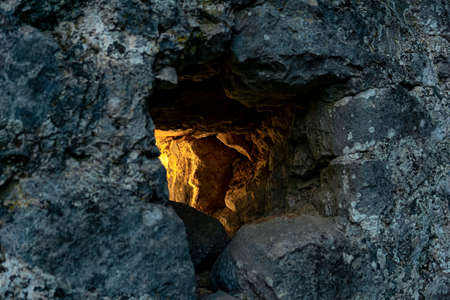 loophole in the ancient fortress wall through which light breaks, close-upの写真素材