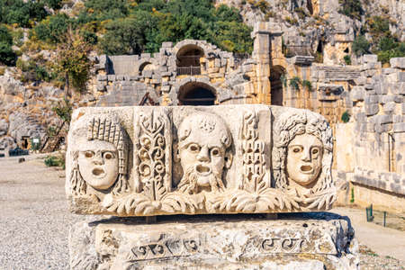 carved stone faces - antique theater masks - in the ruins of the ancient city of Myra, Turkeyの写真素材