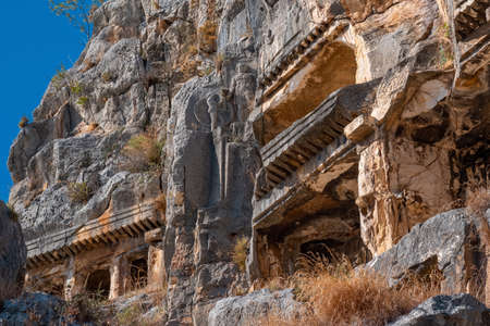 fragment of famous complex of rock tombs in the ruins of Myra with reliefs on the cliffの写真素材