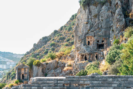 landscape of Demre town in Turkey - rock tombs of ancient Myra on the foreground and modern buildings awayの写真素材