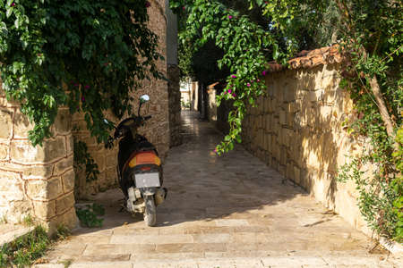 motor scooter parked on a narrow historical street in a mediterranean cityの写真素材