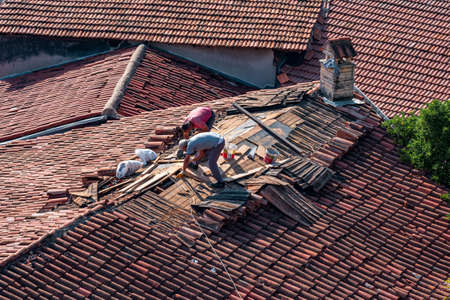 Antalya, Turkey - November 15, 2021: roofers repairing the tiled roof of a historic building in KaleiÃ§iのeditorial素材
