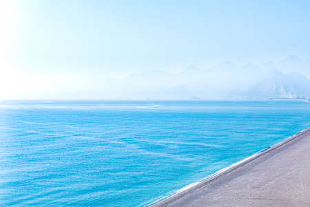 seascape with deserted beach and mountainous shore far away in haze, aerial viewの写真素材