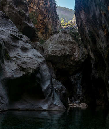 huge stone hangs stuck between two walls of the GÃ¶ynÃ¼k canyon in Turkeyの写真素材