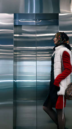 young woman standing waiting for an elevator