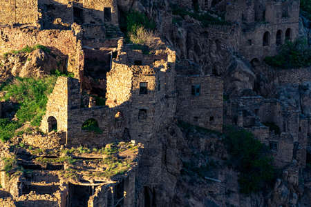 evening view of the ruins of the ghost village of Gamsutl, illuminated by the last rays of the sun