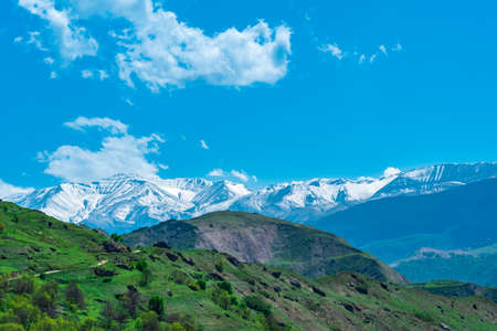 mountain landscape of the North Caucasus, a snow-covered ridge far beyond the alpine meadows